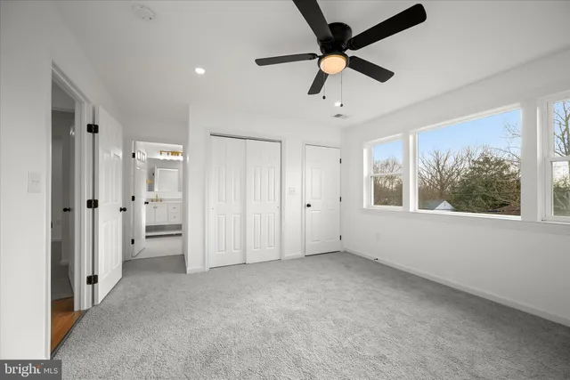 an empty room with a window and a ceiling fan