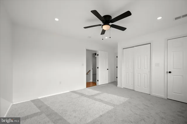 en empty room with window and ceiling fan