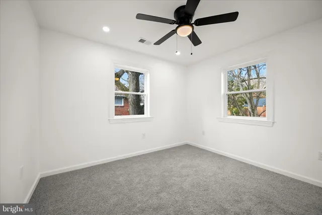 en empty room with window and ceiling fan