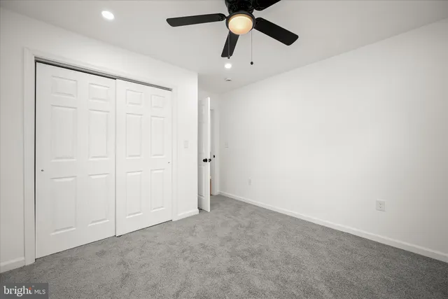 a view of a hallway with white walls and entryway