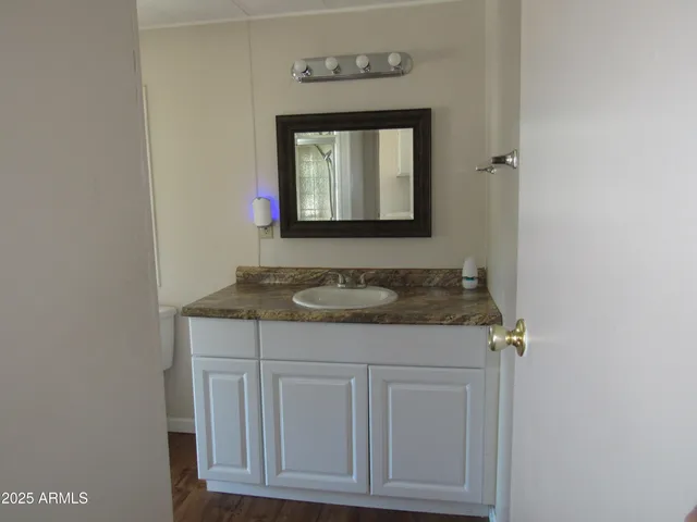 a bathroom with a granite countertop sink and a mirror