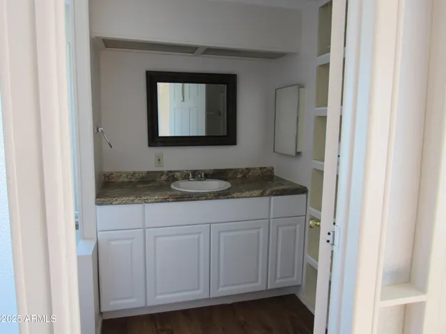 a bathroom with a granite countertop sink and a mirror