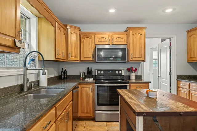 a kitchen with stainless steel appliances granite countertop a refrigerator and a stove top oven