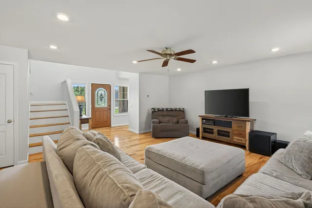 a kitchen with stainless steel appliances granite countertop a refrigerator a stove a sink dishwasher and a dining table with wooden floor