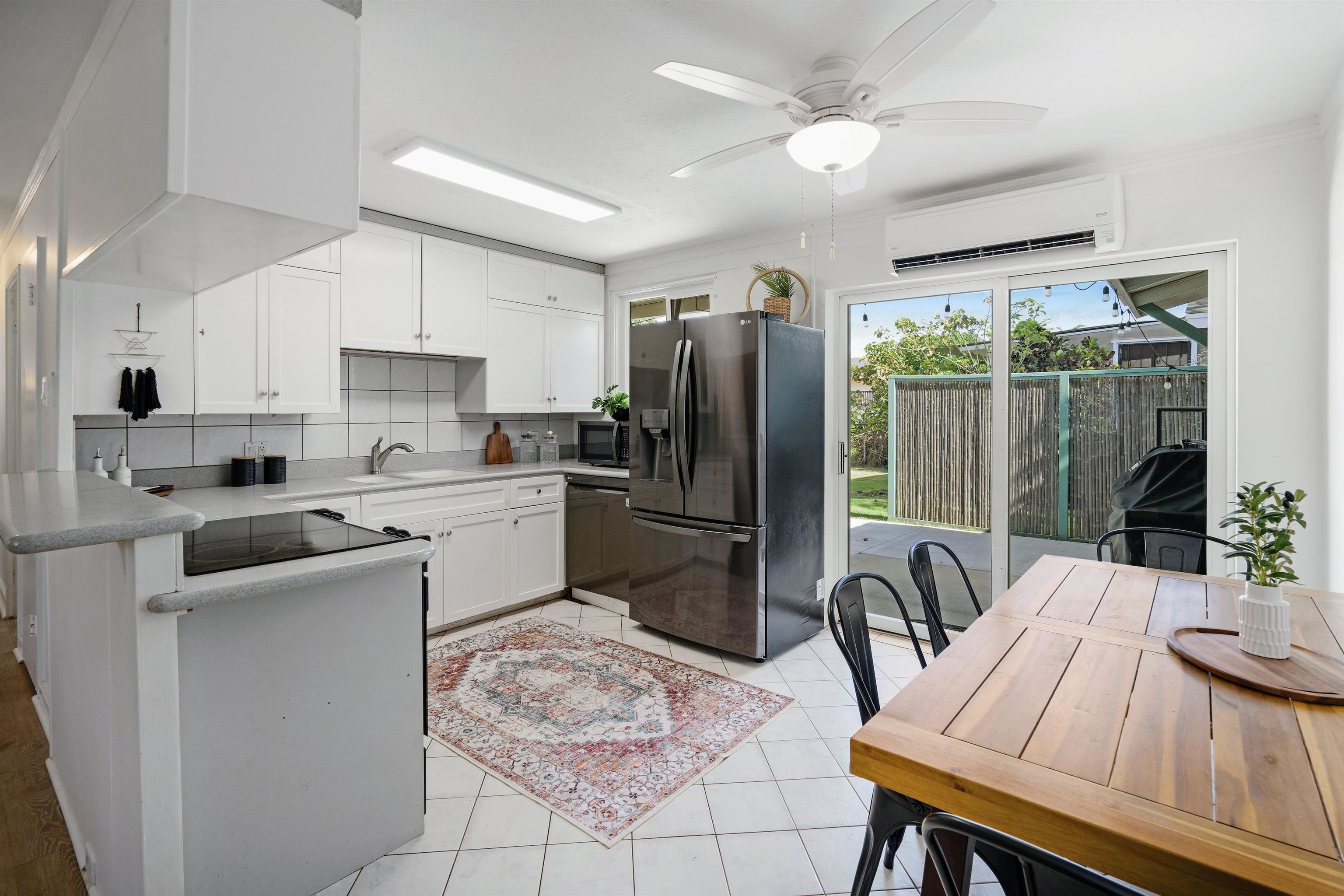 339 Manini Place Kihei, HI 96753 - Photo 6 of 34 a kitchen with a refrigerator a stove a sink dishwasher a dining table and chairs with wooden floor
