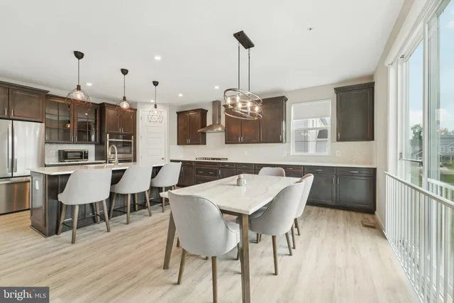 a view of a dining room and livingroom with furniture wooden floor a chandelier