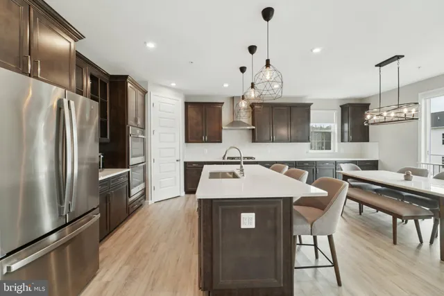 a kitchen with kitchen island a counter space a sink appliances and cabinets