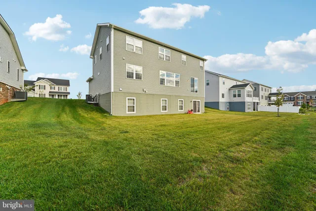 a view of a house with a big yard and large trees