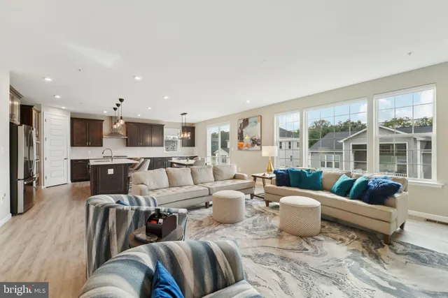 a living room with furniture and a view of kitchen