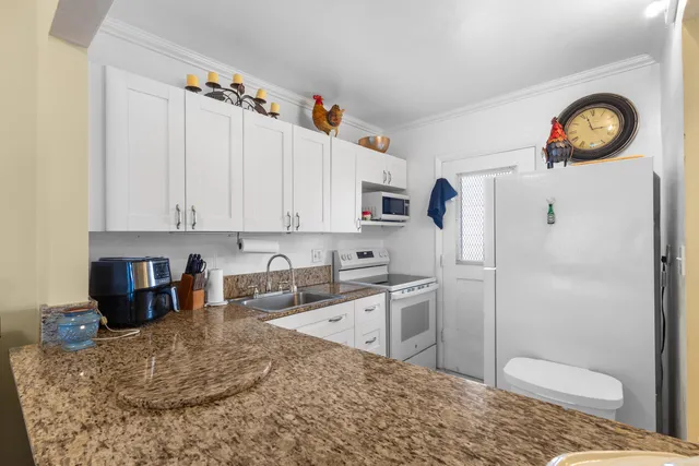 a kitchen with stainless steel appliances granite countertop a refrigerator a stove a sink and dishwasher