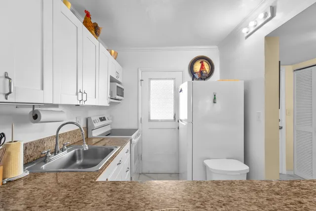 a kitchen with stainless steel appliances granite countertop a sink and a refrigerator