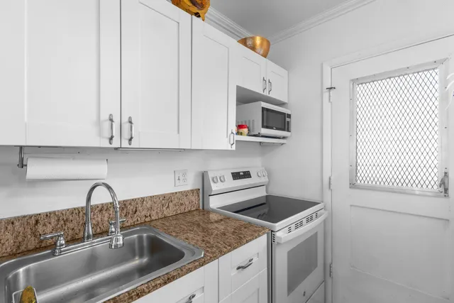 a kitchen with stainless steel appliances granite countertop a sink a stove and a microwave oven