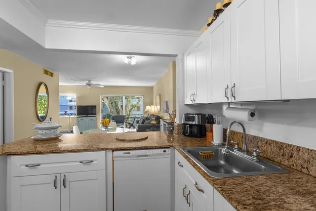 a kitchen with granite countertop a sink stainless steel appliances white cabinets and granite counter tops