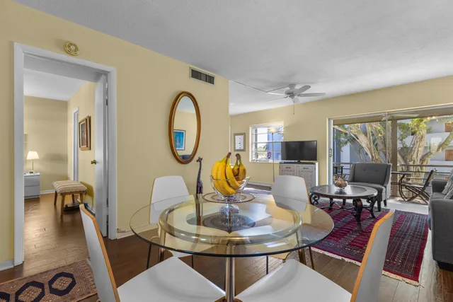 a living room with furniture a table and kitchen view