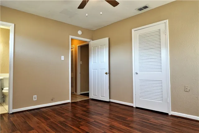 an empty room with wooden floor and closet