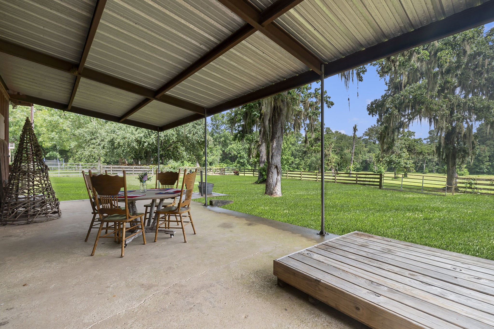 7363 County Line Road Willis, TX 77378 - Photo 23 of 34 Spacious barn patio with serene pasture views.