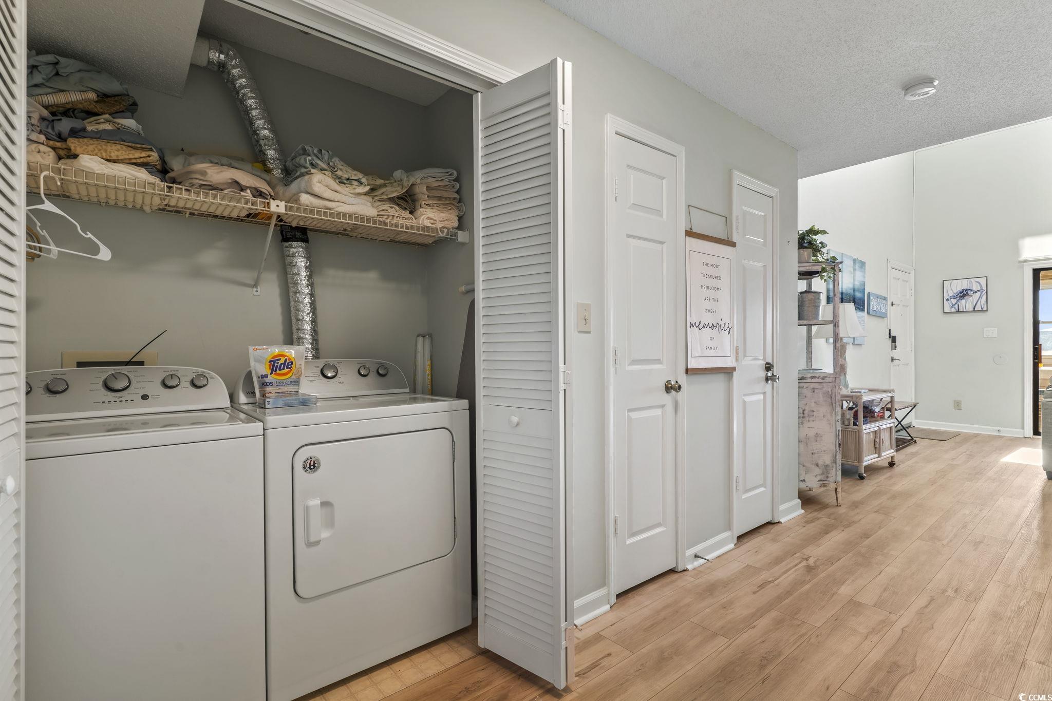 207 Double Eagle Drive, Unit F3 Myrtle Beach, SC 29575 - Photo 17 of 40 Washroom featuring a textured ceiling, light wood-type flooring, and separate washer and dryer