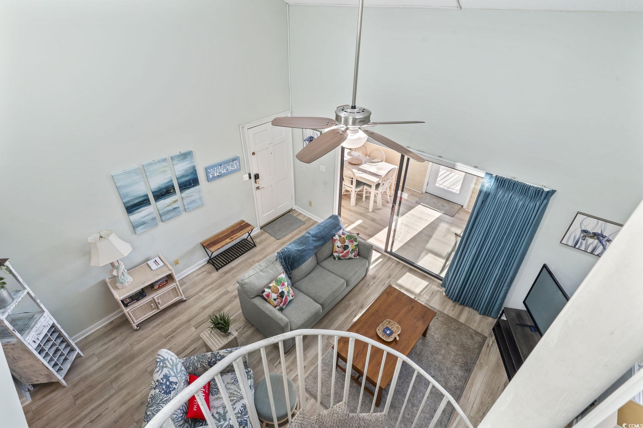207 Double Eagle Drive, Unit F3 Myrtle Beach, SC 29575 - Photo 18 of 40 Living room with a towering ceiling, wood finished floors, and a ceiling fan