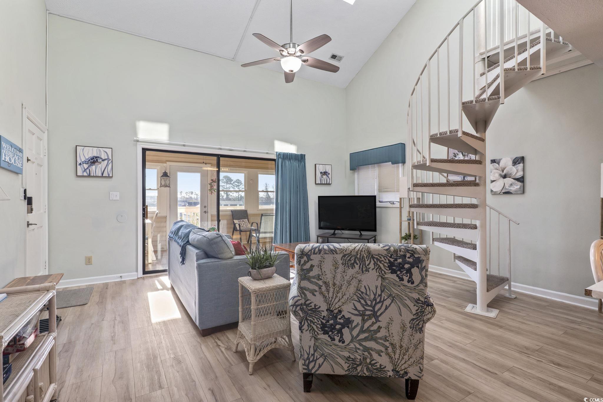207 Double Eagle Drive, Unit F3 Myrtle Beach, SC 29575 - Photo 19 of 40 Living room with light wood-style floors, stairway, ceiling fan, and high vaulted ceiling