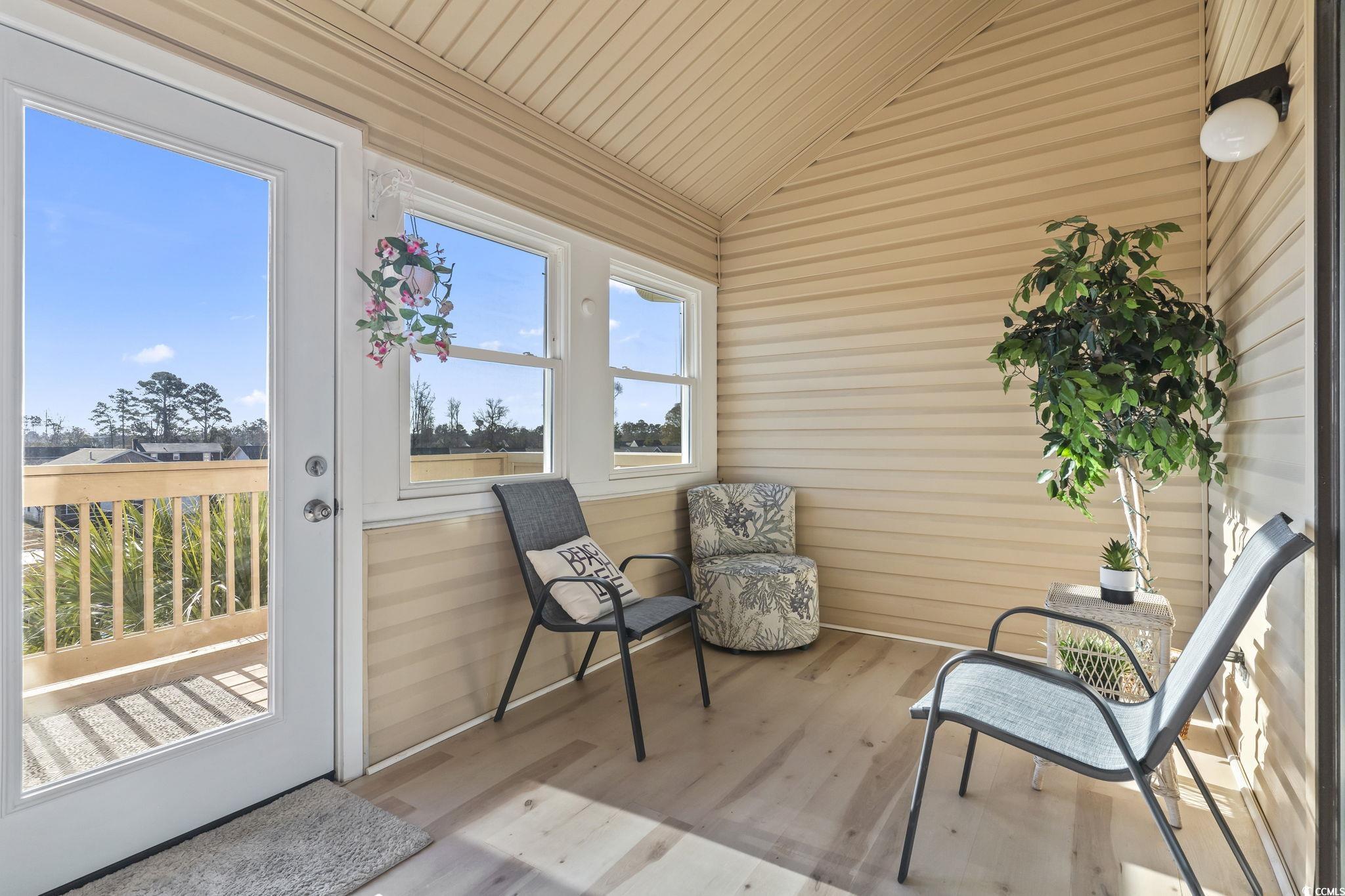 207 Double Eagle Drive, Unit F3 Myrtle Beach, SC 29575 - Photo 23 of 40 Sunroom / solarium featuring lofted ceiling, wood ceiling, wooden walls, and wood finished floors