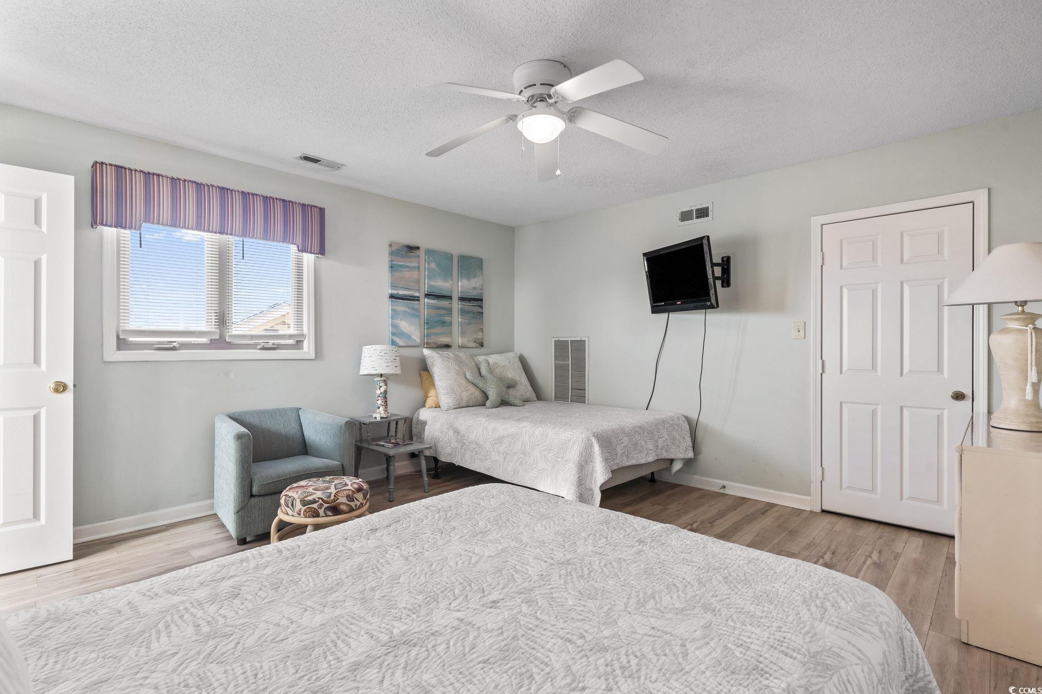 207 Double Eagle Drive, Unit F3 Myrtle Beach, SC 29575 - Photo 29 of 40 Bedroom featuring light wood-type flooring, a textured ceiling, and a ceiling fan