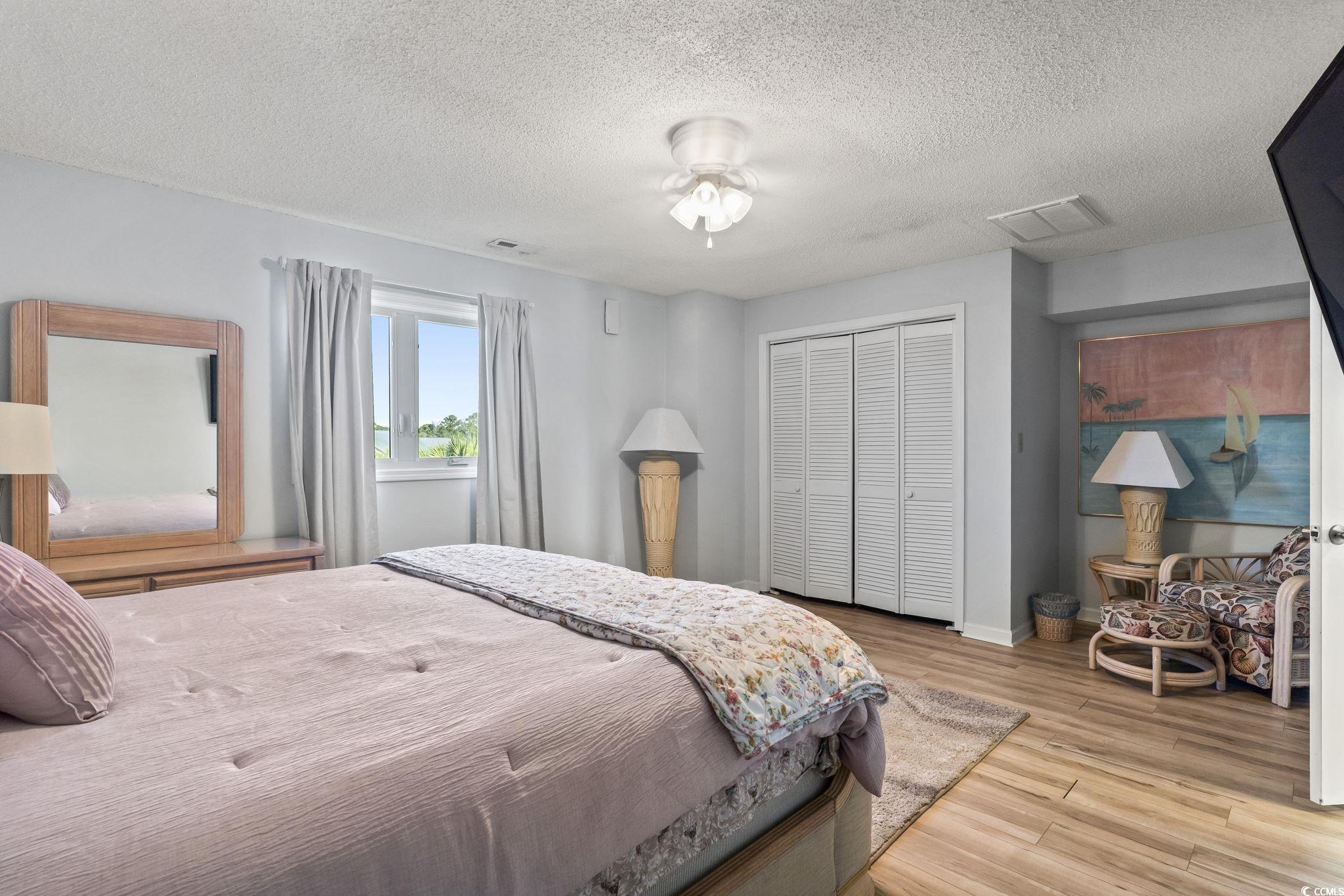 207 Double Eagle Drive, Unit F3 Myrtle Beach, SC 29575 - Photo 33 of 40 Bedroom featuring wood finished floors, a textured ceiling, and a closet