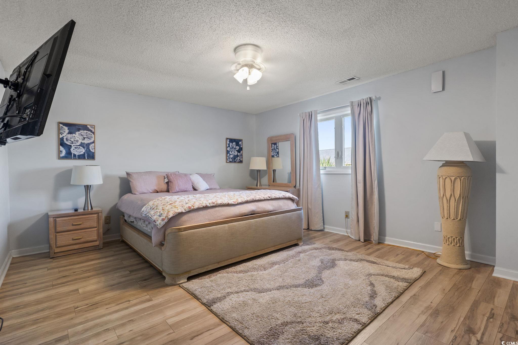 207 Double Eagle Drive, Unit F3 Myrtle Beach, SC 29575 - Photo 35 of 40 Bedroom featuring light wood-style floors and a textured ceiling