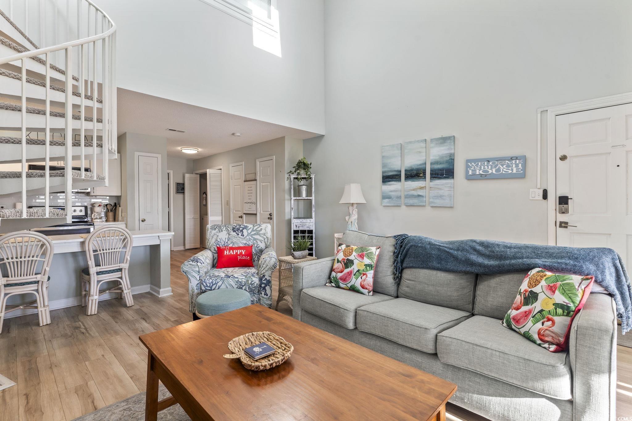 207 Double Eagle Drive, Unit F3 Myrtle Beach, SC 29575 - Photo 6 of 40 Living room featuring a high ceiling and light wood-style flooring