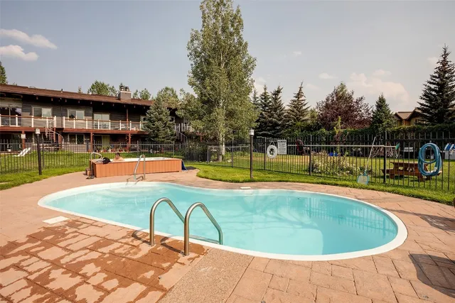 a view of a swimming pool with a yard and a fountain