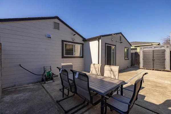 a view of a dinning table and chairs in patio of the house