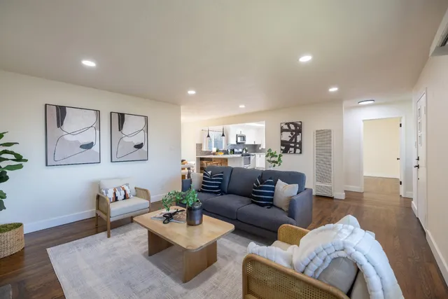a living room with furniture and a wooden floor