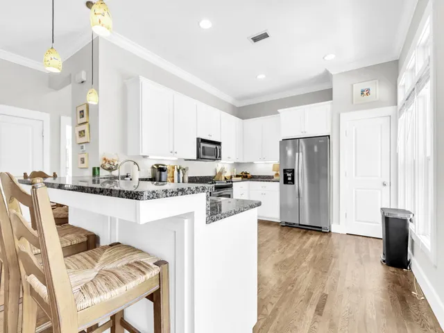 a kitchen with stainless steel appliances a refrigerator a stove a sink dishwasher and a refrigerator with wooden floor