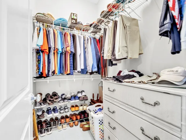 a view of walk in closet with clothes and shoes