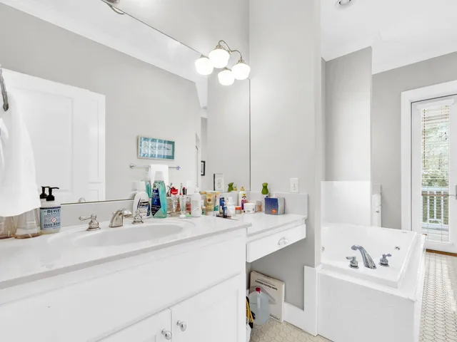 a bathroom with a sink vanity tub and a mirror