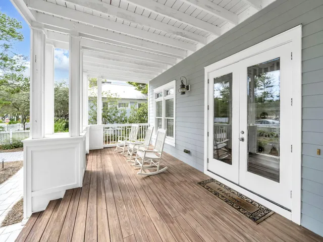 a living room with hardwood floor and large windows
