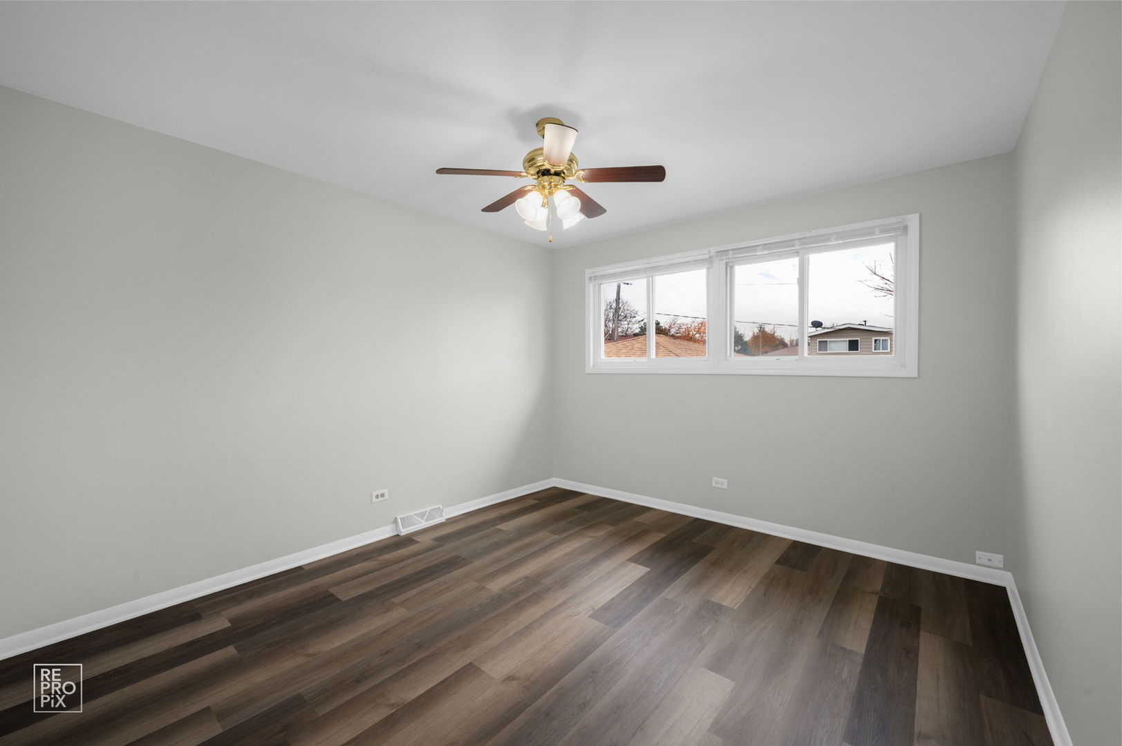 502 East Memorial Road Bensenville, IL 60106 - Photo 11 of 20 an empty room with wooden floor ceiling fan and windows