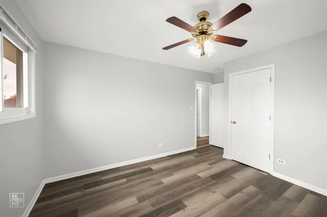 an empty room with fan and windows