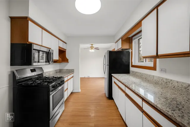 a kitchen with stainless steel appliances granite countertop a stove a sink and a refrigerator