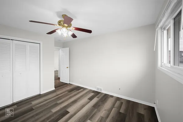 a view of room with hardwood floor and ceiling fan