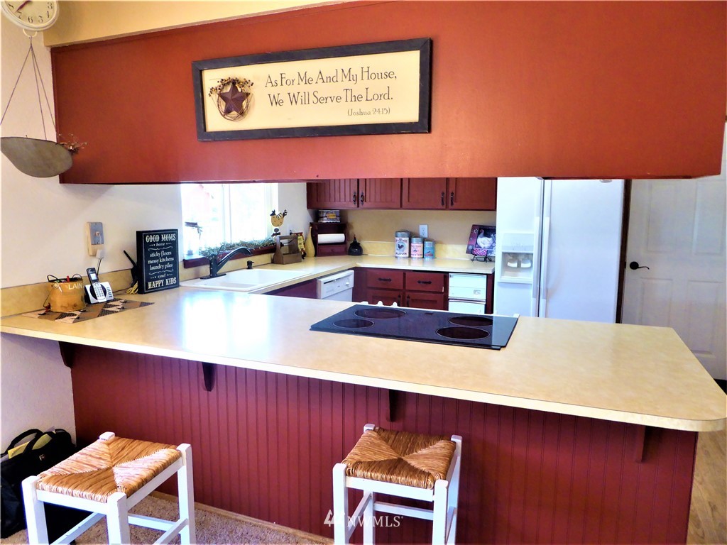 17135 Sargent Road Southwest Rochester, WA 98579 - Photo 11 of 34 a kitchen with stainless steel appliances a sink a stove top oven a counter top space and cabinets