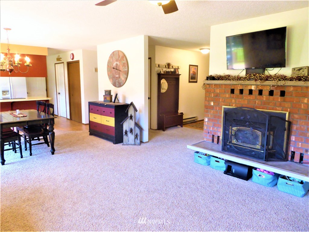 17135 Sargent Road Southwest Rochester, WA 98579 - Photo 13 of 34 a living room with furniture a flat screen tv and a fireplace