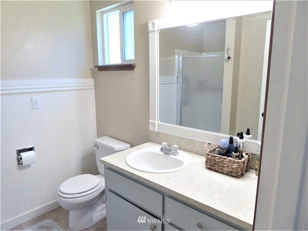 17135 Sargent Road Southwest Rochester, WA 98579 - Photo 21 of 34 a bathroom with a granite countertop sink toilet and mirror