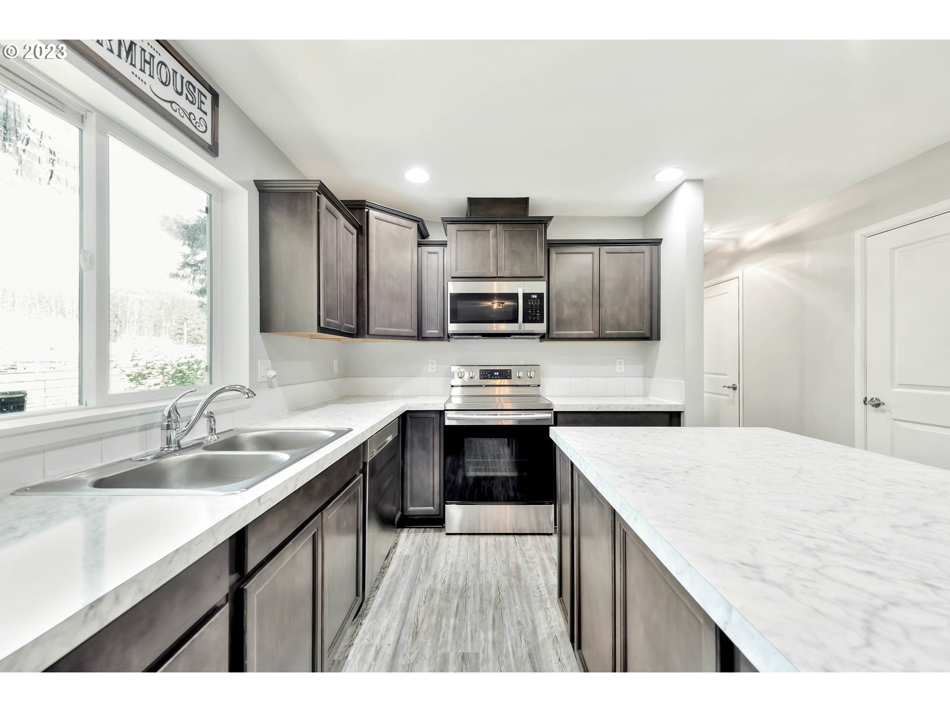 88750 Potter Lane Springfield, OR 97478 - Photo 12 of 43 a kitchen with kitchen island granite countertop a sink stove microwave and refrigerator
