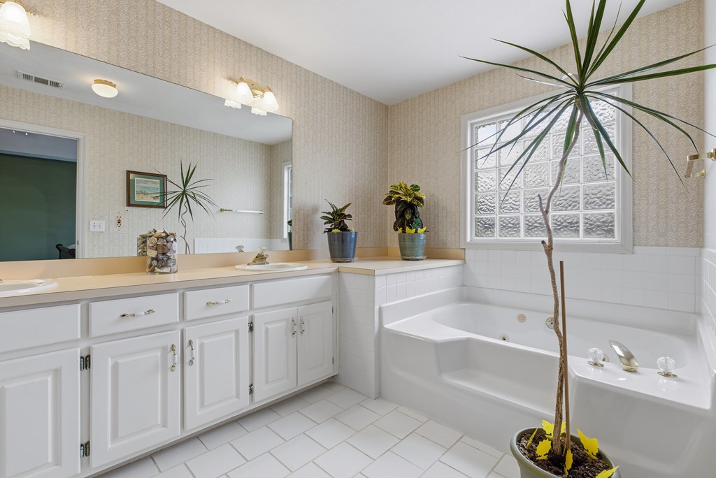 4827 Cedar Ridge Drive Columbus, GA 31909 - Photo 20 of 33 a bathroom with a tub a sink and a large mirror