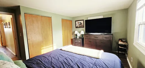 a bedroom with a bed and flat screen tv