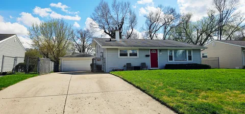 a front view of a house with yard porch and tree