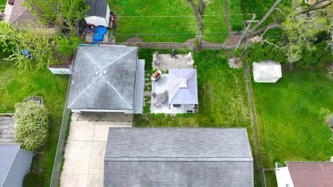 an aerial view of a house with a yard basket ball court and outdoor seating
