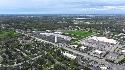 an aerial view of city lake and trees