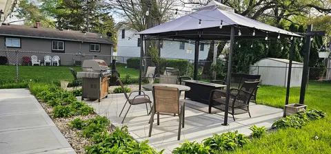 a view of a patio with table and chairs under an umbrella