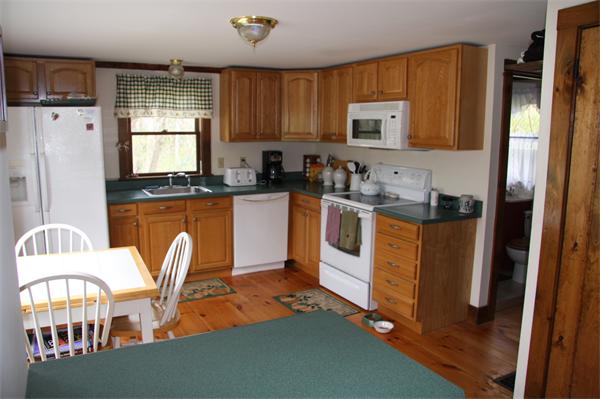 289 Hurricane Hill Road Mason, NH 03048 - Photo 12 of 30 a kitchen with stainless steel appliances granite countertop a refrigerator a stove top oven a sink dishwasher and white cabinets with wooden floor